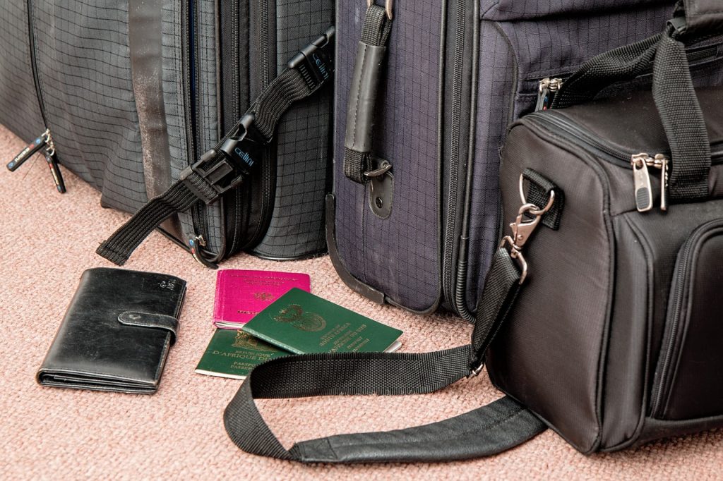 torby podróżne i leżące przed nimi paszporty oraz portfel